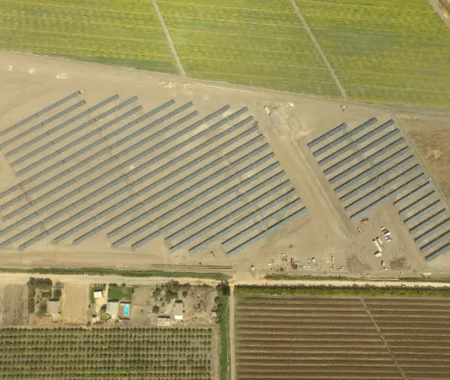 Vista aérea de una planta fotovoltaica junto a terrenos agrícolas