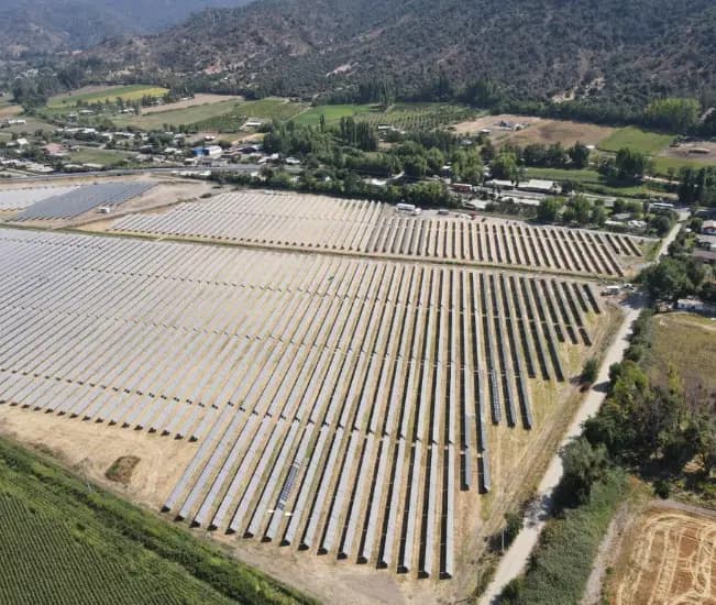 Vista aérea de una planta fotovoltaica terminada en un valle agrícola